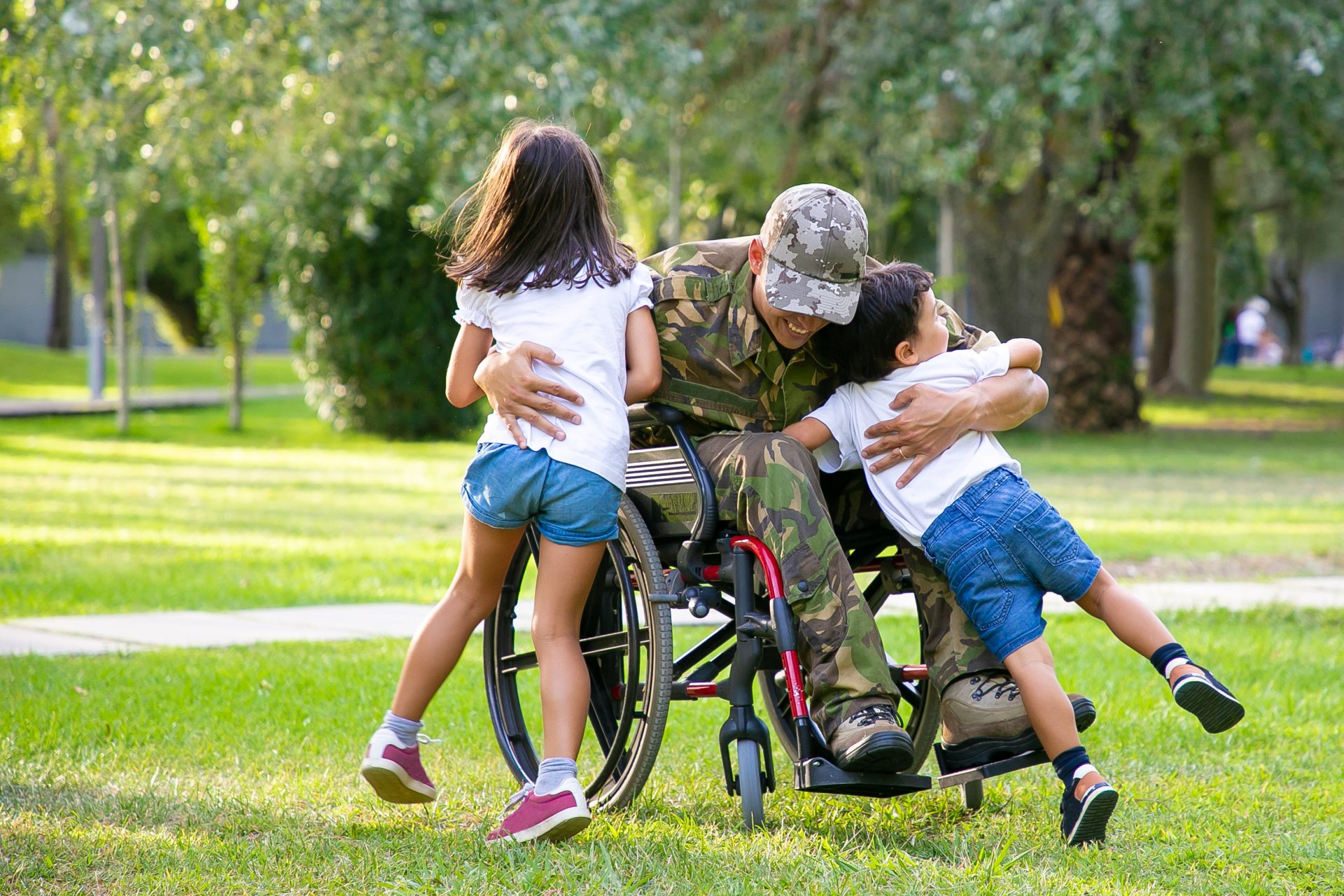 A wounded veteran hugging his children in a park